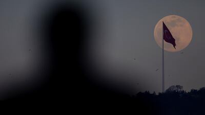 A man watches on as an almost full pink supermoon rises over Istanbul in Istanbul, Turkey. Getty Images
